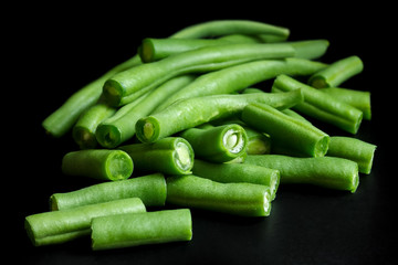 Whole French green string beans cut and isolated on black.