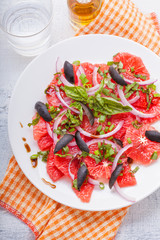 Grapefruit salad with olives, red onion, basil