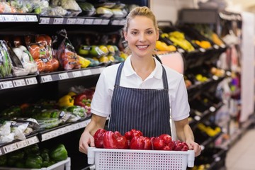 Portrait of a smiling blonde worker holding a vegetables 