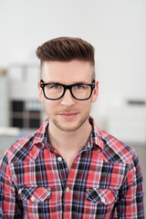 junger mann mit schwarzer brille im büro
