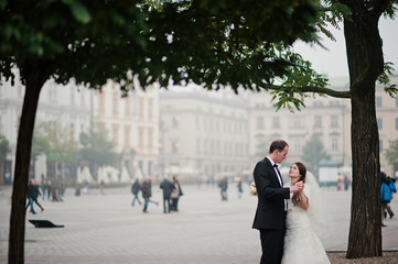 Young elegant and hearty wedding couple in love on streets of Kr