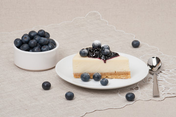 Cheese Cake With Blueberry Jam And Blueberries On White Plate