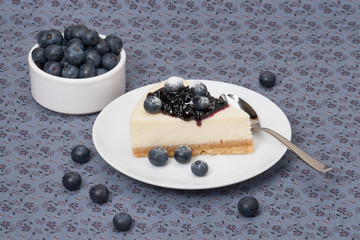 Cheese Cake With Blueberry Jam And Blueberries On White Plate