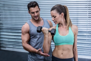 A muscular woman lifting dumbbells