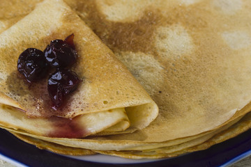 Pancakes with jam on a wooden background.