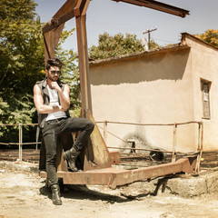 handsome man model dressed punk, hipster posing dramatic in grun