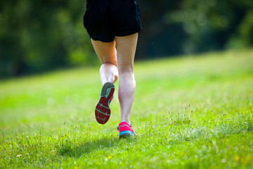  Young women jogging at park . Close-up photo of her legs