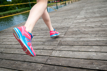  Young women jogging at wooden bridge  . Close-up photo of her legs