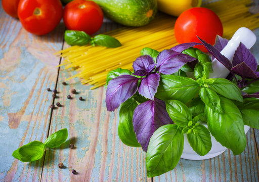 Pasta, tomatoes, and basil on wooden background
