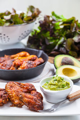 Grilled chicken legs and wings with guacamole
