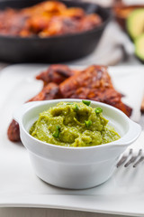 Grilled chicken legs and wings with guacamole