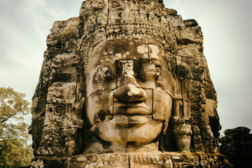 Fototapeta na wymiar Enigmatic smiling giant stone face of Bayon temple, Angkor Thom