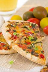Veggie Pizza - Vegetarian mini pizza on a wooden background.