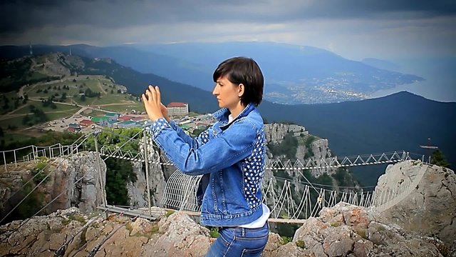 Girl making a panorama in the mountains on the smartphone