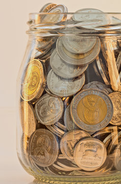 silver and gold coloured coins in a glass jar