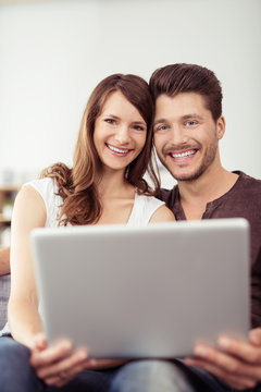 Sweet Happy Young Couple Holding Laptop Together
