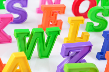 Plastic colorful alphabet letters close up on a white