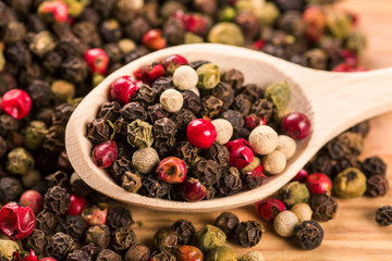 Pepper seeds in wooden spoon on wood table