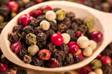 Pepper seeds in wooden spoon on wood table