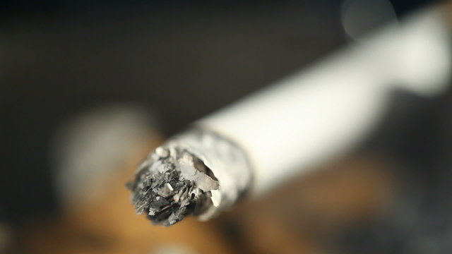 Burning cigarette with smoke in ashtray