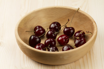 fresh ripe cherry in a wooden plate