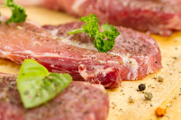 fresh raw pork on cutting Board with spices and herbs.  ?lose up