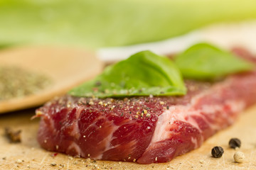 fresh raw pork on cutting Board with spices and herbs.  ?lose up