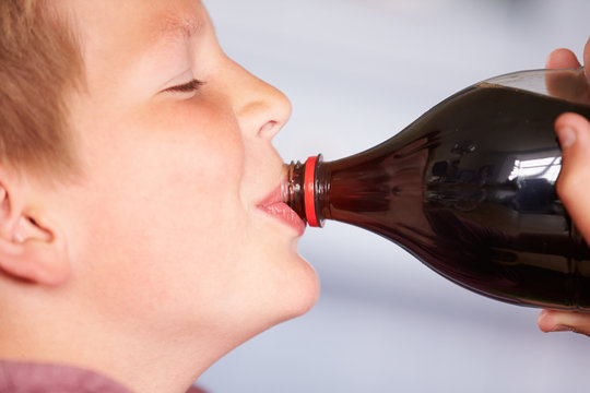 Close Up Of Boy Drinking Soda From Bottle