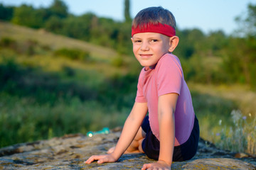 Athletic Boy Doing Side Planking on Top of Boulder