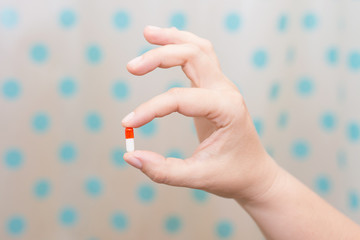 Female hand holding a pill