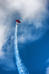 Red biplane aircraft in the blue sky
