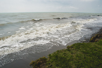 landscape by the sea, choppy water,  lowering sky, toned