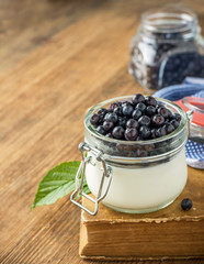 Fototapeta na wymiar Milk cream with fresh blueberries for breakfast in the glass batch pot