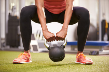 Woman exercising with a kettlebell weight, front view low-sectio