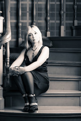 Beautiful woman sitting on the stairs and looking into the camer