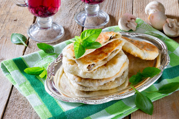 Pastry stuffed with mushrooms and onions on a wooden table
