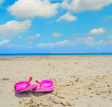 pink flip flops on the sand in Sardinia