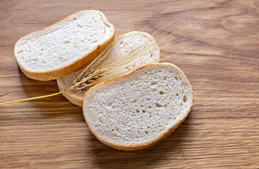 Bread and wheat on wooden background 