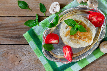Pastry stuffed with mushrooms and onions on a wooden table,  top view