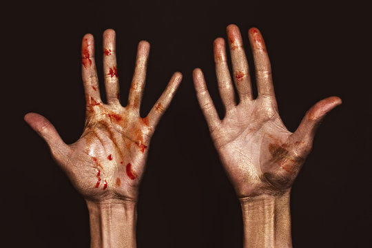 Hands in golden and red paint