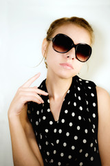 Portrait of the girl in sunglasses on a light background