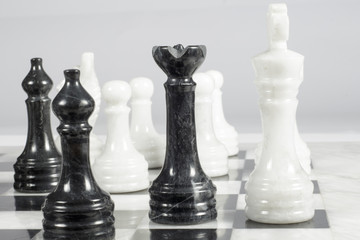 The black queen checkmates. Marble chessboard