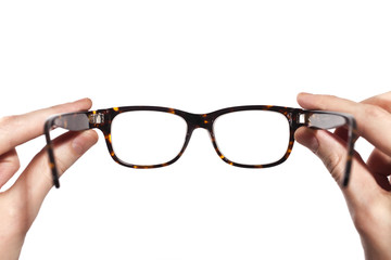 glasses with horn-rimmed in human hands isolated