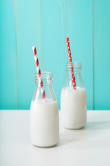 Two milk bottles with red colored straw