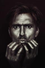 studio portrait of young attractive blue-eyed men with gold make