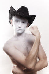 young naked man in cowboy hat with white makeup