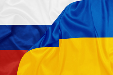 Russia and Ukraine national flags on silk texture