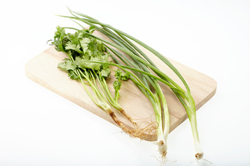 Parsley and scallion on chopping block isolated on white backgro