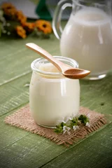 Foto auf Acrylglas yogurt bianco nel vasetto di vetro sul tavolo verde © al62