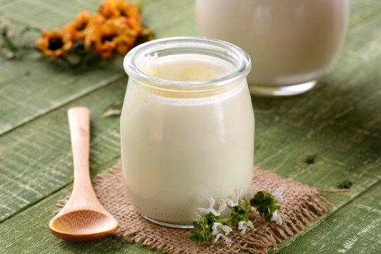 yogurt bianco nel vasetto di vetro sul tavolo verde